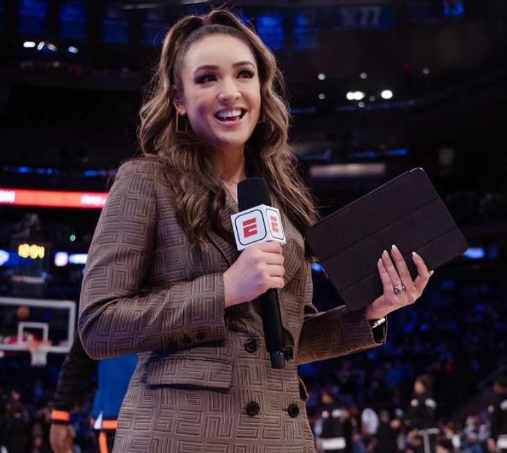 Picture of Cassidy Hubbarth hosting NBA with beautiful dress on posing for a picture with mic on her right hand